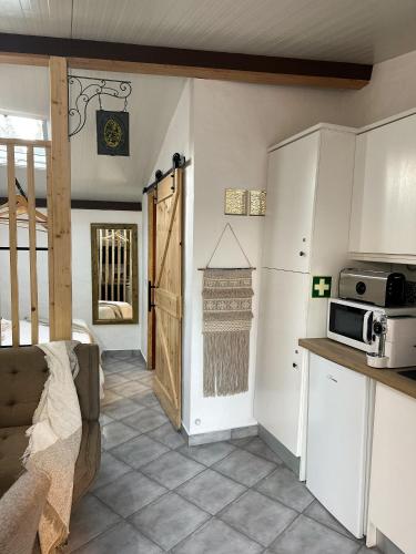 a kitchen with a microwave and a door to a room at Estúdio em Alte - KARMEA HOUSES in Alte