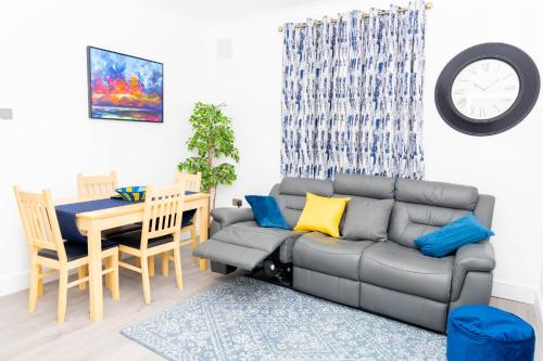 uma sala de estar com um sofá e uma mesa em 4 bedroom Bungalow em Slades Green