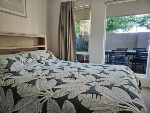 a bedroom with a bed with a floral comforter at North Adelaide Apartment in Adelaide