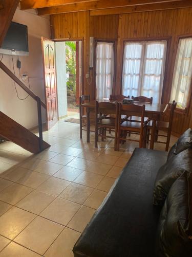 een woonkamer met een tafel en stoelen en een bank bij El Pindo Iguazu in Puerto Iguazú