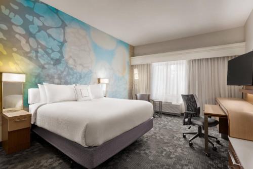 a hotel room with a bed and a desk at Courtyard by Marriott Palmdale in Palmdale