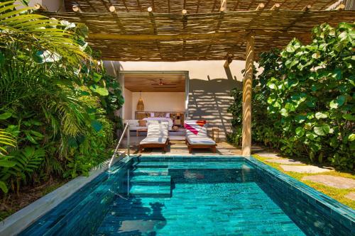 a swimming pool in a backyard with a pergola at W Punta de Mita in Punta Mita