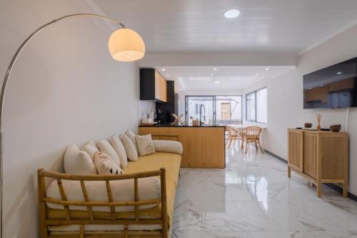 a living room with a couch and a kitchen at Casa da Antonieta in Ponta Delgada