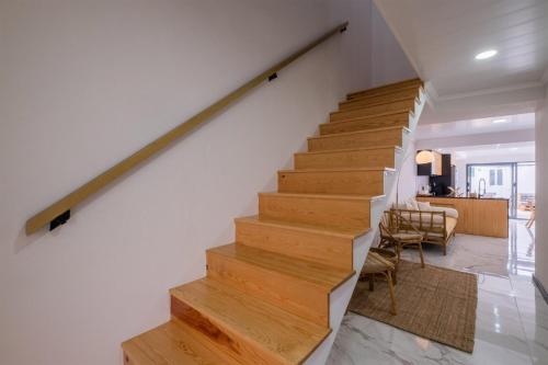 een trap in een huis met witte muren en houten vloeren bij Casa da Antonieta in Ponta Delgada