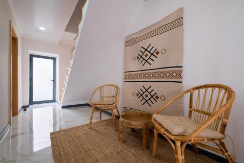 a living room with two chairs and a wall at Casa da Antonieta in Ponta Delgada