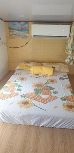 a bed with a flower pattern on it in a room at Daet Transient Tiny House staycation 2-6px in Daet