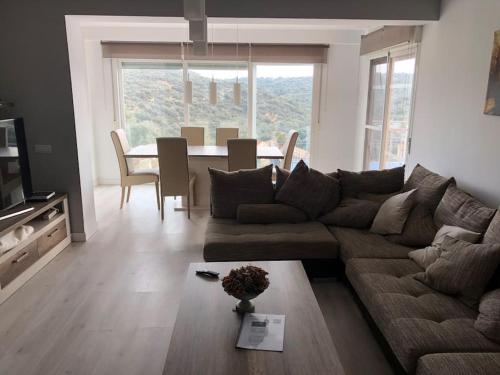 ein Wohnzimmer mit einem Sofa und einem Tisch in der Unterkunft El Encinar de Carol in Mesones
