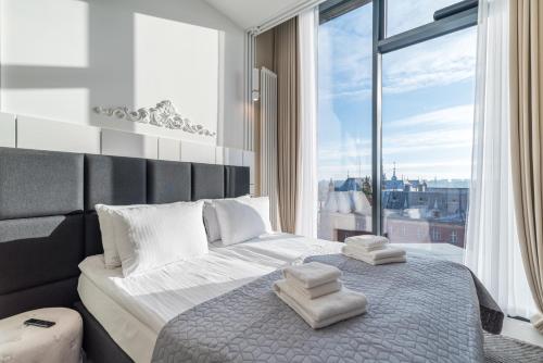 a bedroom with a large bed with towels on it at Q18 ApartHotel in Bydgoszcz