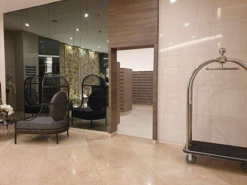 een salon met stoelen en een douche in de kamer bij HOMESNAP CONDOTEL FAME RESIDENCE MANDALUYONG in Manilla