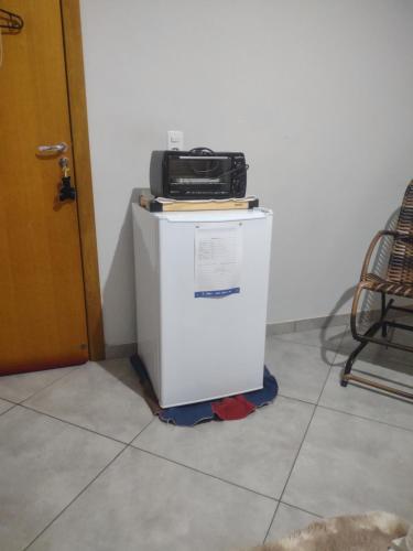 a microwave sitting on top of a refrigerator at Casa Fortes in Várzea Grande