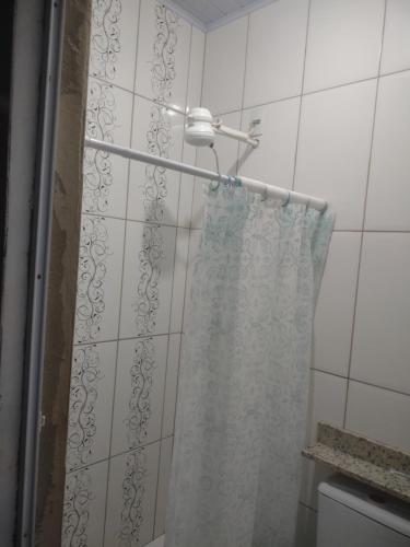 a shower with a shower curtain in a bathroom at Casa Fortes in Várzea Grande