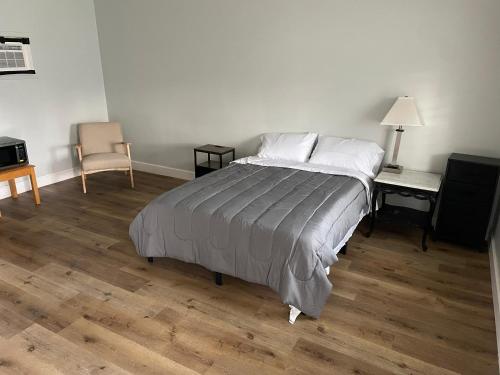 a bedroom with a bed and a desk and a chair at Deland Motel in De Land