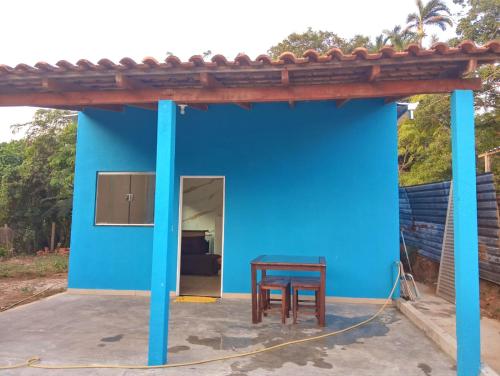 a blue house with a table and a chair in it at Casa Azul in Passos