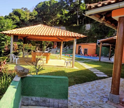 a garden with a green bench and a pavilion at Sitio maravilharara in Miguel Pereira