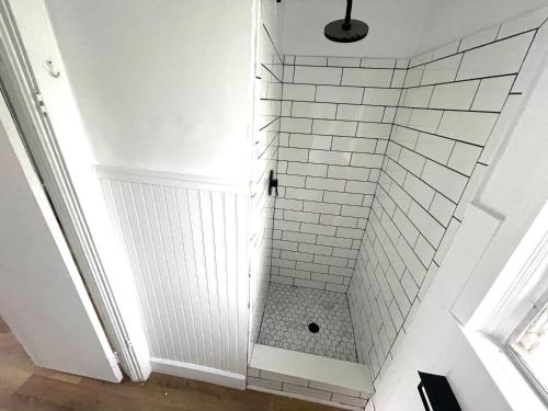 a bathroom with a shower with white subway tiles at Deland Motel in De Land