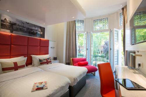 a bedroom with a large bed and a red headboard at Henley House Hotel in London