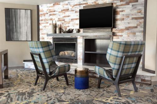 a living room with two chairs and a fireplace at Residence Inn by Marriott Corona Riverside in Corona