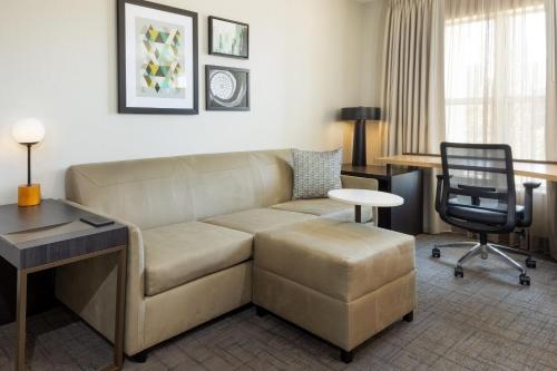 a living room with a couch and a desk and a chair at Residence Inn by Marriott Corona Riverside in Corona
