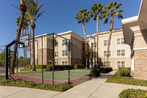 a tennis court in front of a building with palm trees at Residence Inn by Marriott Corona Riverside in Corona