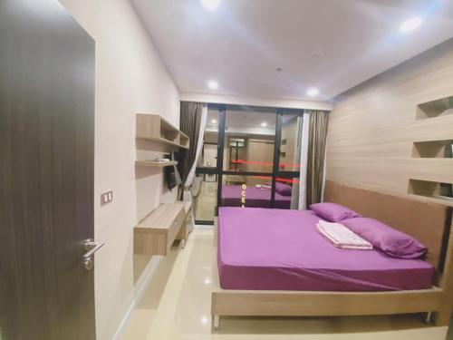 um pequeno quarto com uma cama roxa num quarto em dusit grand condo view高层海景房 em Praia de Jomtien