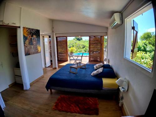 1 dormitorio con 1 cama y 1 mesa en una habitación en L'Auxilliadora - Studio cozy en bord de mer, en Sainte-Anne