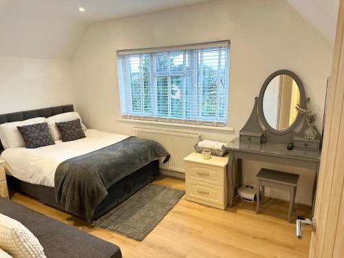 a bedroom with a bed and a desk and a mirror at Charming 3-Bed Home Minutes From City Centre in Nottingham