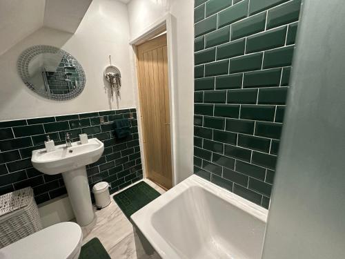 a bathroom with a toilet and a sink and a tub at Charming 3-Bed Home Minutes From City Centre in Nottingham