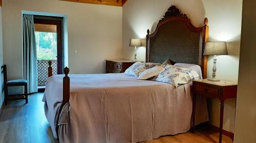 a bedroom with a large bed with a wooden headboard at Charming house in Povoa de Lanhoso with shared pool in Póvoa de Lanhoso