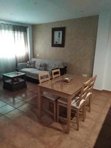 uma sala de estar com uma mesa e um sofá em El Celemín em Benalup Casas Viejas