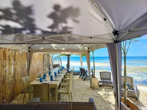 una mesa larga en la playa bajo una sombrilla en Swakihan Guest House, en Siquijor