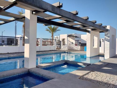 a swimming pool in the middle of a building with a pergola at STARFISH Maeva Residencial in Puerto Peñasco