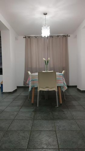 a dining room with a table with a vase of flowers on it at Apartment nice neighborhood in Maracay