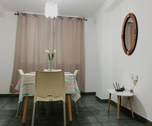 a dining room with a table and chairs and a mirror at Apartment nice neighborhood in Maracay
