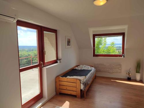 um quarto com uma cama e duas janelas em Holiday home in Zamardi - Balaton 45334 em Zamárdi