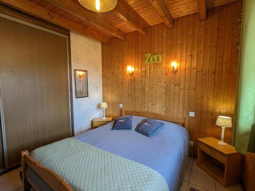 ein Schlafzimmer mit einem Bett in einem Holzzimmer in der Unterkunft Gîte Rochesson, 4 pièces, 7 personnes - FR-1-589-167 in Rochesson
