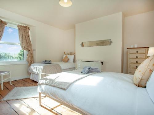a bedroom with two beds and a window at Uk45542-the Farm House in Sticklepath