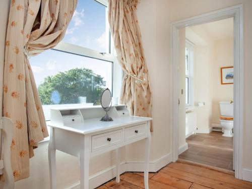 a white dressing table in a room with a window at Uk45542-the Farm House in Sticklepath