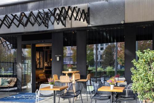 a patio with tables and chairs in front of a building at Hotel Indigo Antwerp City Centre by IHG in Antwerp