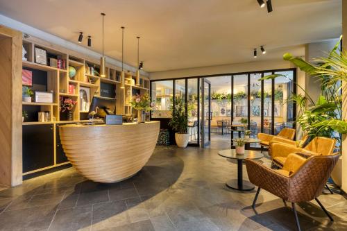 a lobby with a large wooden orb in the middle at Hotel Indigo Antwerp City Centre by IHG in Antwerp