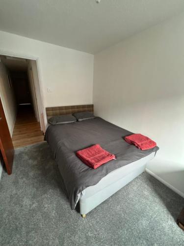 a bedroom with a bed with two red towels on it at Goodwin Apartments in Carlisle