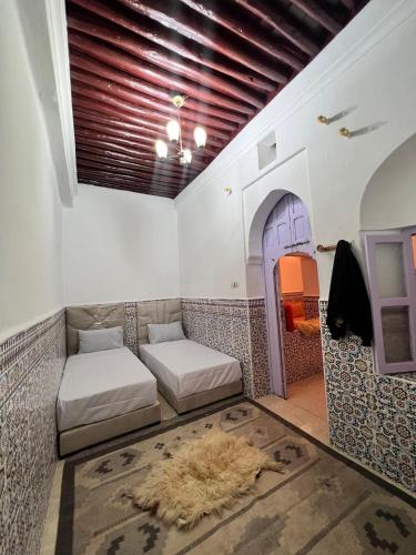 a room with two beds in a room with an archway at Dar mi Yamna in Rabat