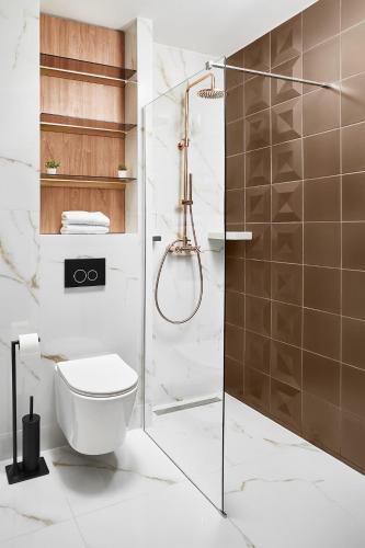 a bathroom with a toilet and a glass shower at 21st Century Zlatibor Residence, Spa & Wellness by Adora in Zlatibor