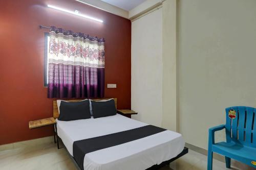 a bedroom with a bed and a blue chair at OYO 8195 The Hotel Lotus Inn in Nagpur