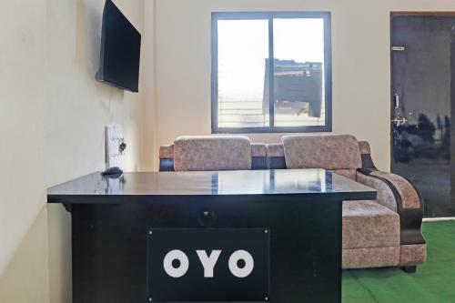 a table with a couch and a tv in a room at OYO 8195 The Hotel Lotus Inn in Nagpur