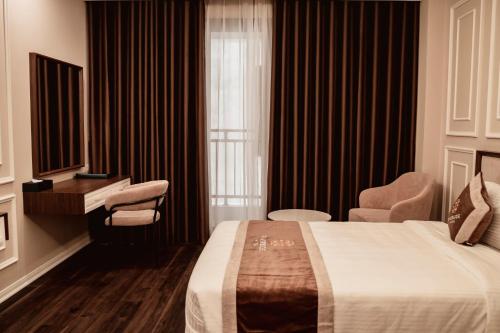 a hotel room with a bed and a desk at Riverside Hotel Hà Nam in Phủ Lý