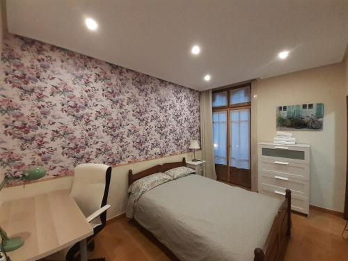 um quarto com uma cama, uma secretária e uma mesa em Uría 25 rooms em Oviedo