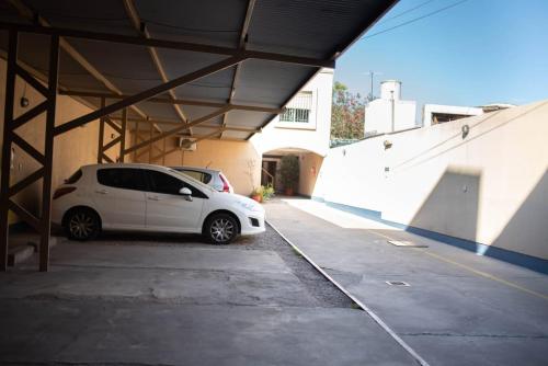 una macchina bianca parcheggiata in un parcheggio di Hostel Los Andes a Guaymallén