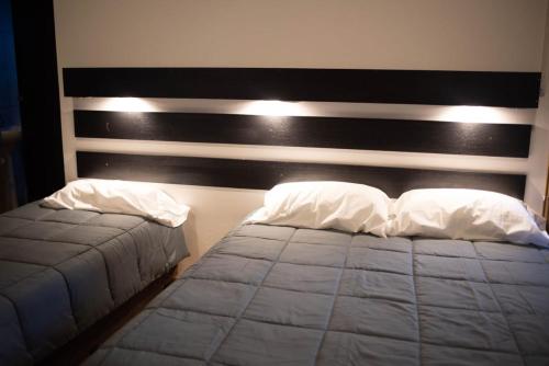 um quarto com uma cama e uma cabeceira em preto e branco em Hostel Los Andes em Guaymallen