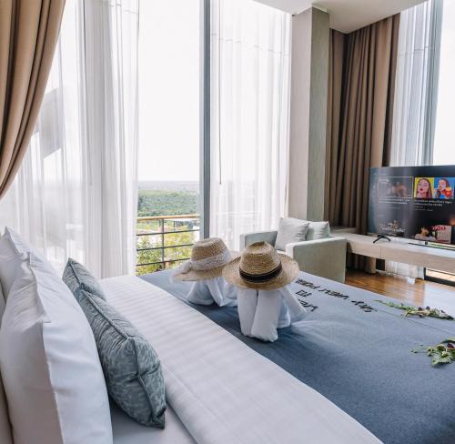 a hotel room with two people sitting on a bed at Sky View Luxury Pool Villa - SHA in Surat Thani