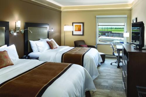 Habitación de hotel con 2 camas y escritorio en AeroStay, en Sioux Falls